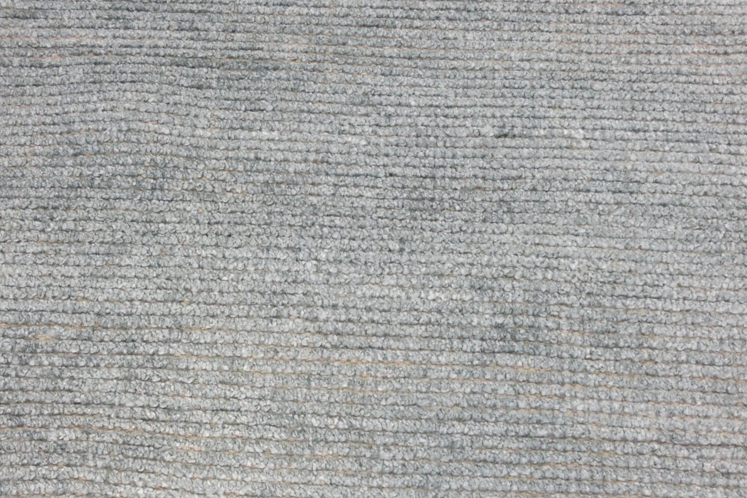 A close-up texture shot of a gray and white ribbed fabric or carpet material.
