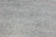A close-up texture shot of a gray and white ribbed fabric or carpet material.
