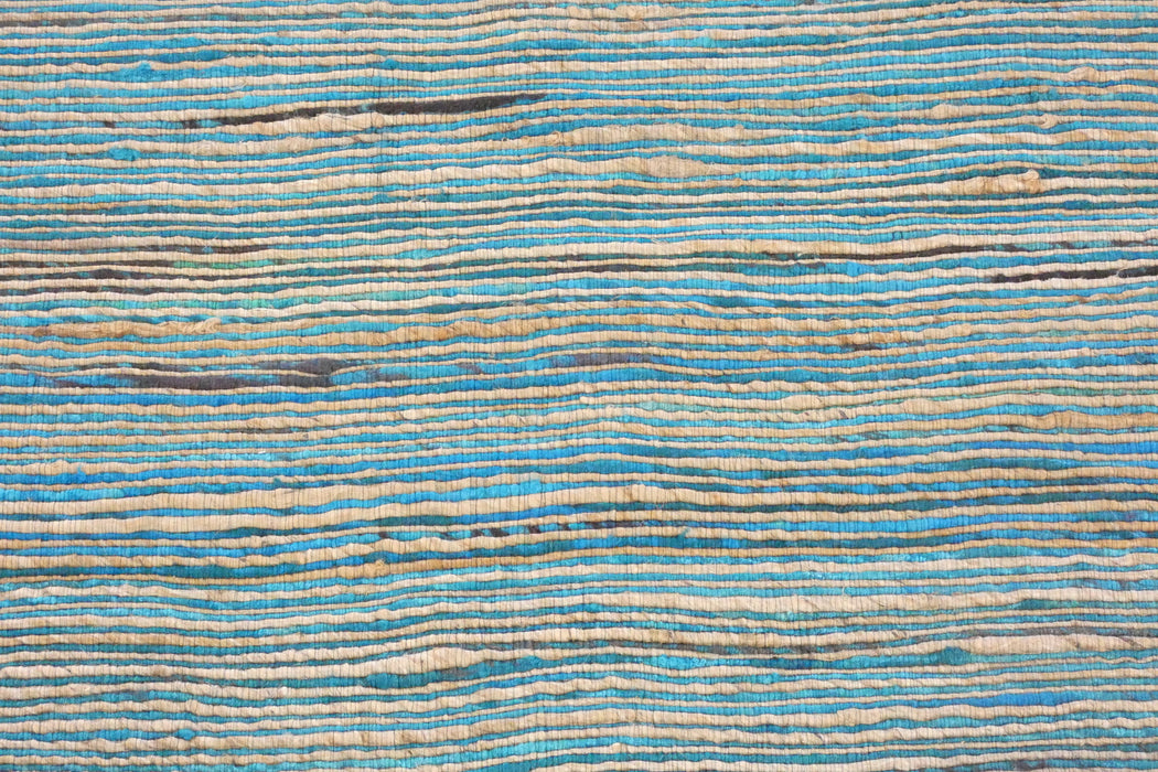 A close-up of a textured fabric or wallpaper pattern featuring horizontal wavy stripes in shades of blue, beige, and brown.