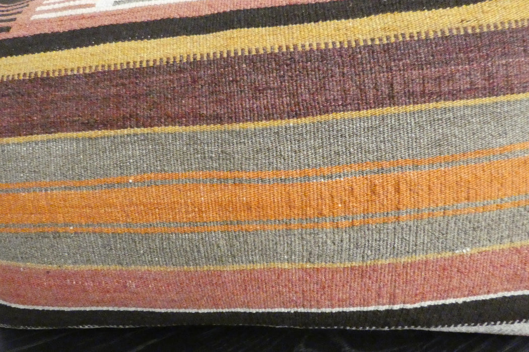 A close-up of a woven textile with horizontal stripes in olive green, orange, burgundy, mustard yellow, and black.