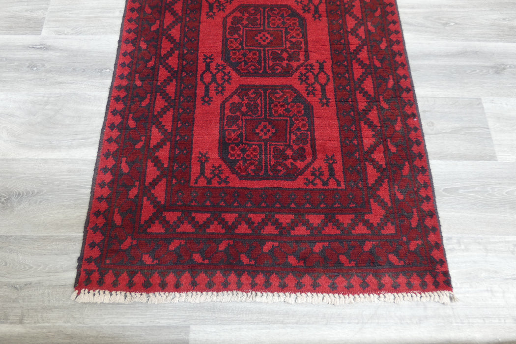 Red Afghan Turkman Bokhara hand-knotted wool rug featuring traditional repeating Gul medallions, 100 × 200 cm.Rugs Direct NZ