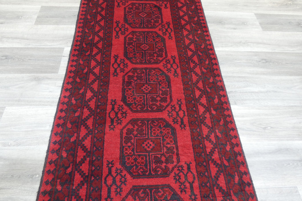 Red Afghan Turkman Bokhara hand-knotted wool rug featuring traditional repeating Gul medallions, 100 × 200 cm.Rugs Direct NZ