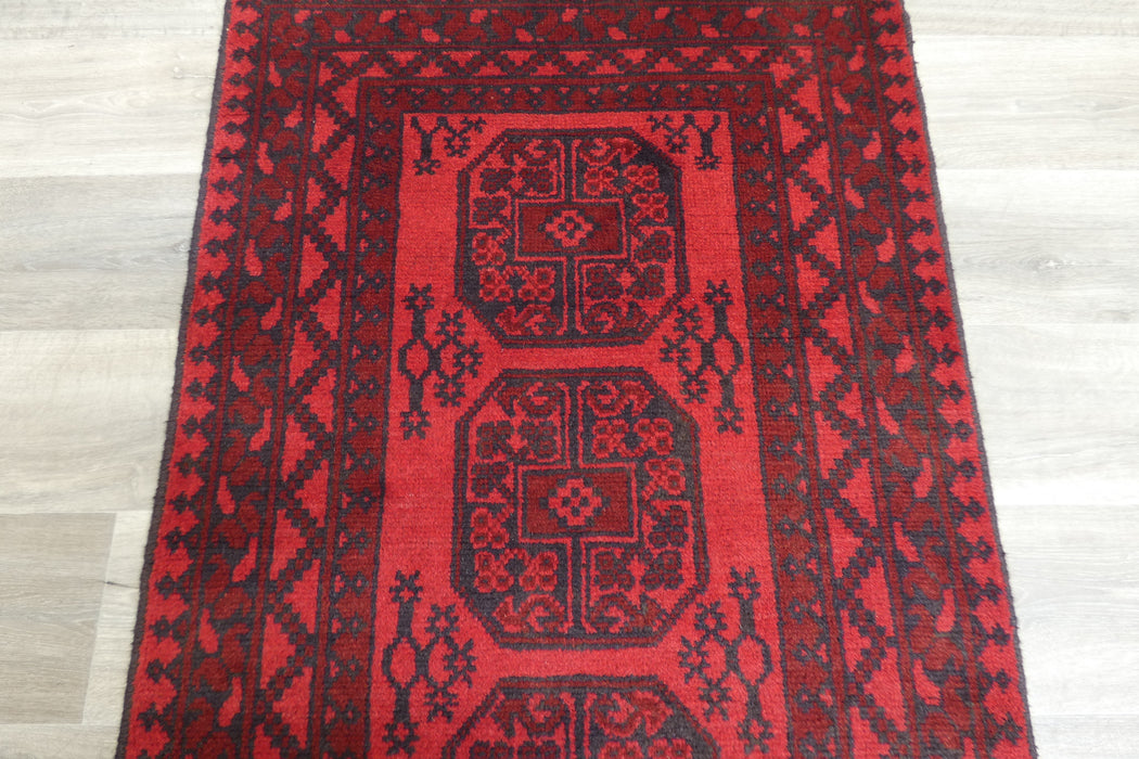 Red Afghan Turkman Bokhara hand-knotted wool rug featuring traditional repeating Gul medallions, 100 × 200 cm.Rugs Direct NZ