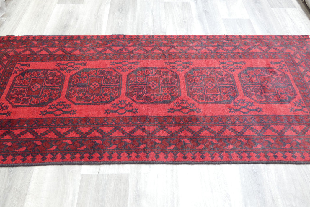 Red Afghan Turkman Bokhara hand-knotted wool rug featuring traditional repeating Gul medallions, 100 × 200 cm.Rugs Direct NZ