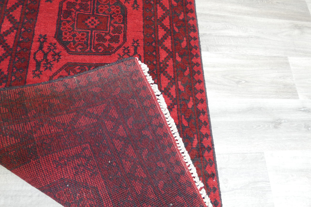 Red Afghan Turkman Bokhara hand-knotted wool rug featuring traditional repeating Gul medallions, 100 × 200 cm.Rugs Direct NZ