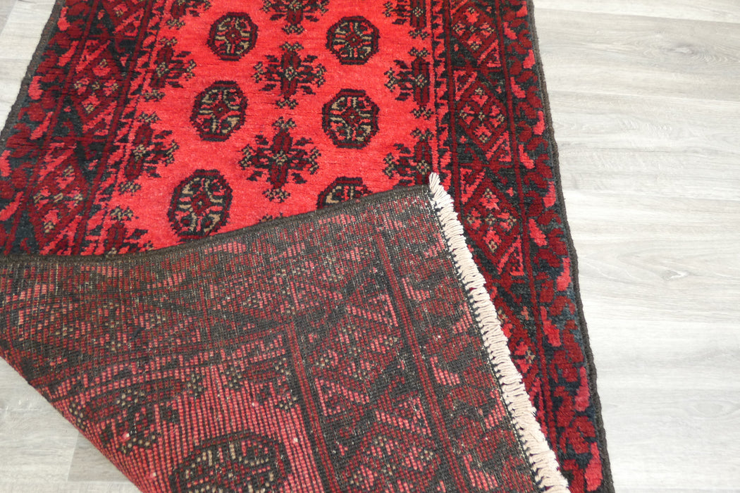 Red Afghan Turkman Bokhara hand-knotted wool rug featuring traditional repeating Gul medallions, .Rugs Direct NZ