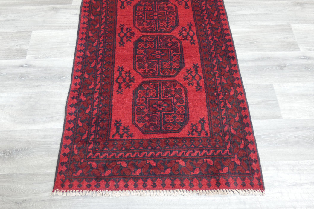 Red Afghan Turkman Bokhara hand-knotted wool rug featuring traditional repeating Gul medallions, 100 × 200 cm.Rugs Direct NZ