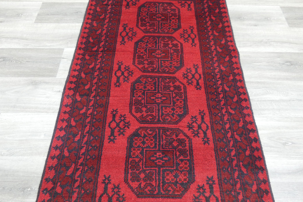 Red Afghan Turkman Bokhara hand-knotted wool rug featuring traditional repeating Gul medallions, 100 × 200 cm.Rugs Direct NZ