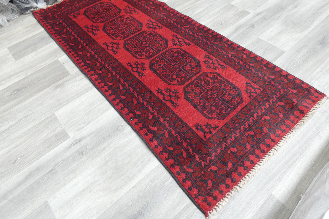 Red Afghan Turkman Bokhara hand-knotted wool rug featuring traditional repeating Gul medallions, 100 × 200 cm.Rugs Direct NZ