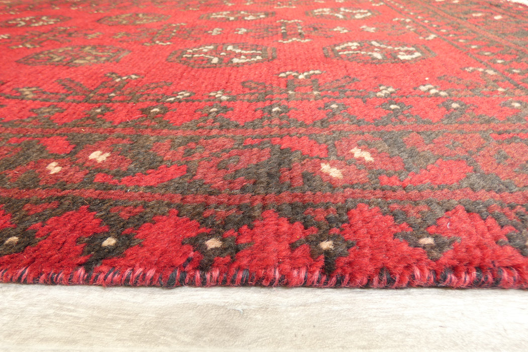 Red Afghan Turkman Bokhara hand-knotted wool hallway runner featuring repeating oval Gul medallions and traditional geometric borders.Rugs Direct NZ