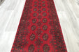 Red Afghan Turkman Bokhara hand-knotted wool hallway runner featuring repeating oval Gul medallions and traditional geometric borders.Rugs Direct NZ