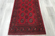 Red Afghan Turkman Bokhara hand-knotted wool hallway runner featuring repeating oval Gul medallions and traditional geometric borders.Rugs Direct NZ