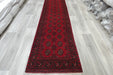 Red Afghan Turkman Bokhara hand-knotted wool hallway runner featuring repeating oval Gul medallions and traditional geometric borders.Rugs Direct NZ