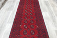 Red Afghan Turkman Bokhara hand-knotted wool hallway runner featuring repeating oval Gul medallions and traditional geometric borders. Rugs Direct NZ