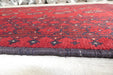 Red Afghan Turkman Bokhara hand-knotted wool hallway runner featuring repeating oval Gul medallions and traditional geometric borders. Rugs Direct NZ