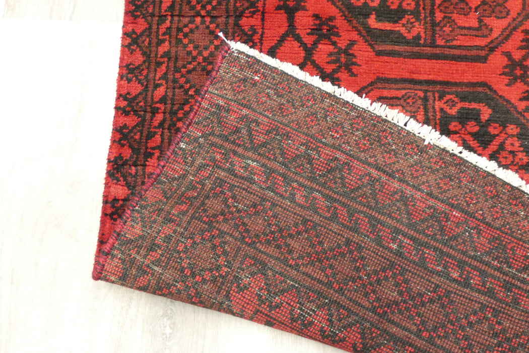 Red Afghan Turkman Bokhara hand-knotted wool hallway runner featuring repeating oval Gul medallions and traditional geometric borders.Rugs Direct NZ