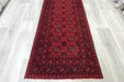 Red Afghan Turkman Bokhara hand-knotted wool hallway runner featuring repeating oval Gul medallions and traditional geometric borders.Rugs Direct NZ