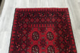 Red Afghan Turkman Bokhara hand-knotted wool hallway runner featuring repeating oval Gul medallions and traditional geometric borders.Rugs Direct NZ