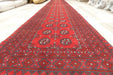 Red Afghan Turkman Bokhara hand-knotted wool hallway runner featuring repeating oval Gul medallions and traditional geometric borders. Rugs Direct NZ